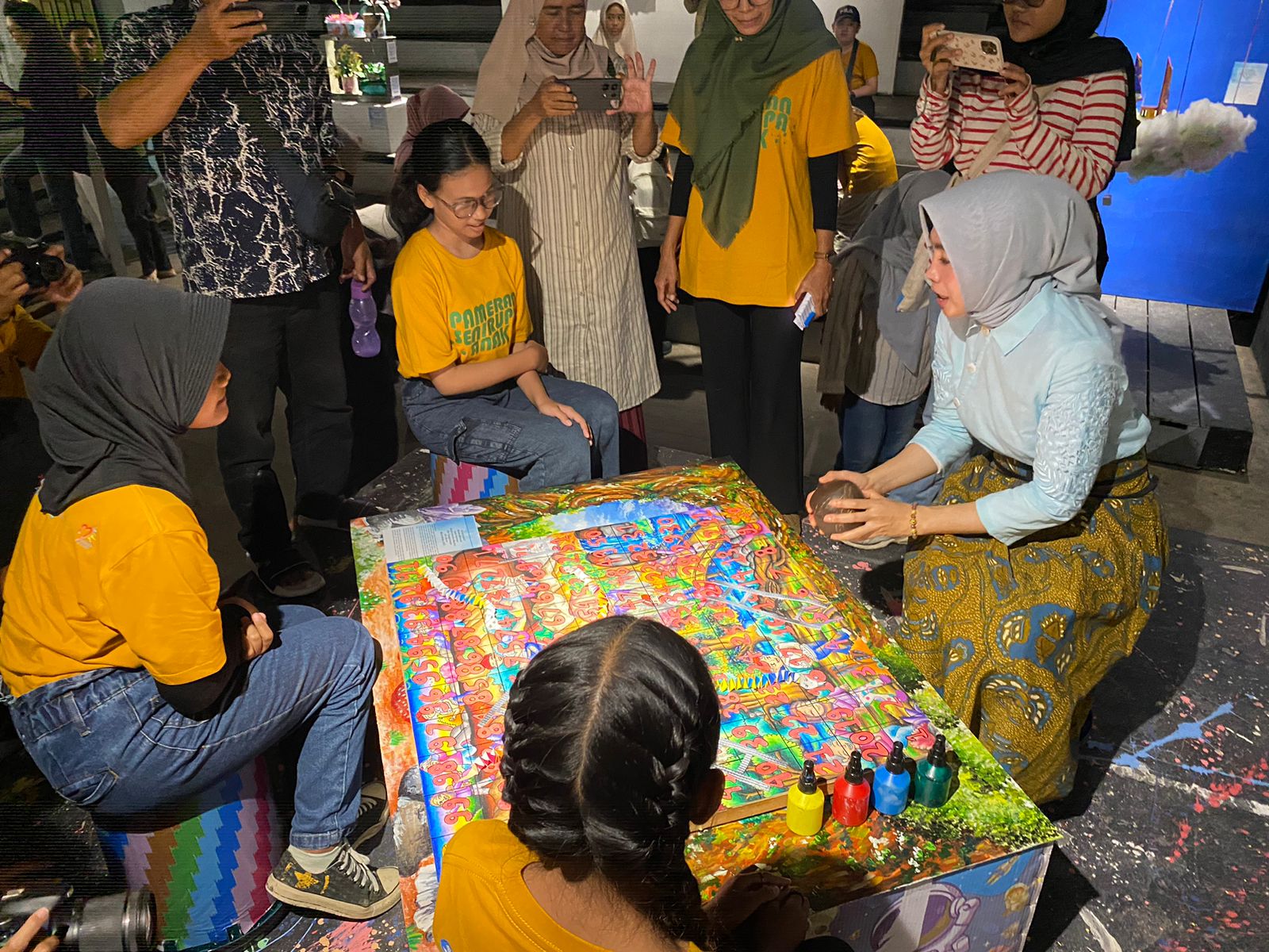 BERMAIN : Kepala Disdikbud Kalbar, Rita Hastarita, mencoba bermain ular tangga bersama anak-anak di sela kunjungan ke Pameran Seni Rupa Anak di Taman Budaya Kalbar, Rabu (24/7).