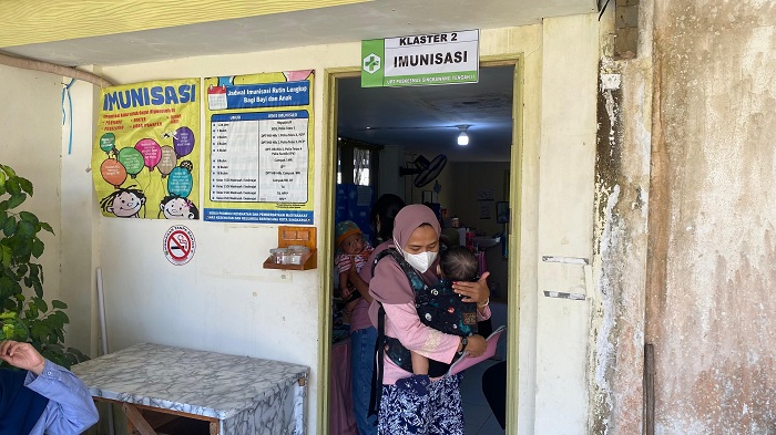IMUNISASI : Seorang ibu membawa anaknya untuk diimunisasi di salah satu puskesmas di Kota Singkawang.