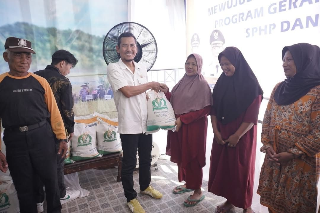 KETAHANAN PANGAN: Ketua DPRD Ketapang, Achmad Sholeh, menyerahkan beras SPHP kepada salah satu penerima bantuan dalam program TNI&ndash;Bulog Bersinergi di Kodim 1203 Ketapang, Kamis (24/7). Program ini men