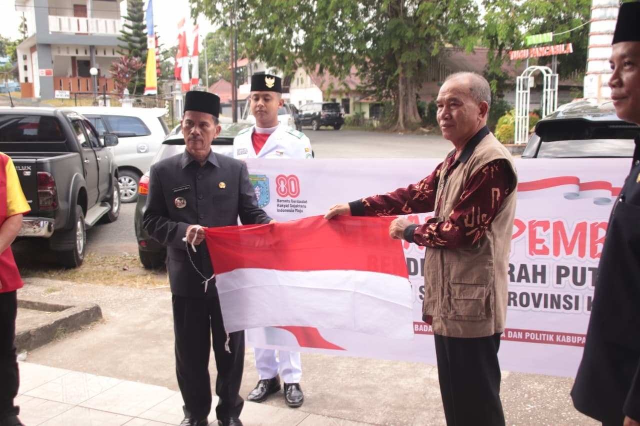 Bupati Sintang Gregorius Herkulanus Bala menyerahkan bendera Merah Putih kepada perwakilan warga di depan Gedung Pancasila, Jumat (1/8).