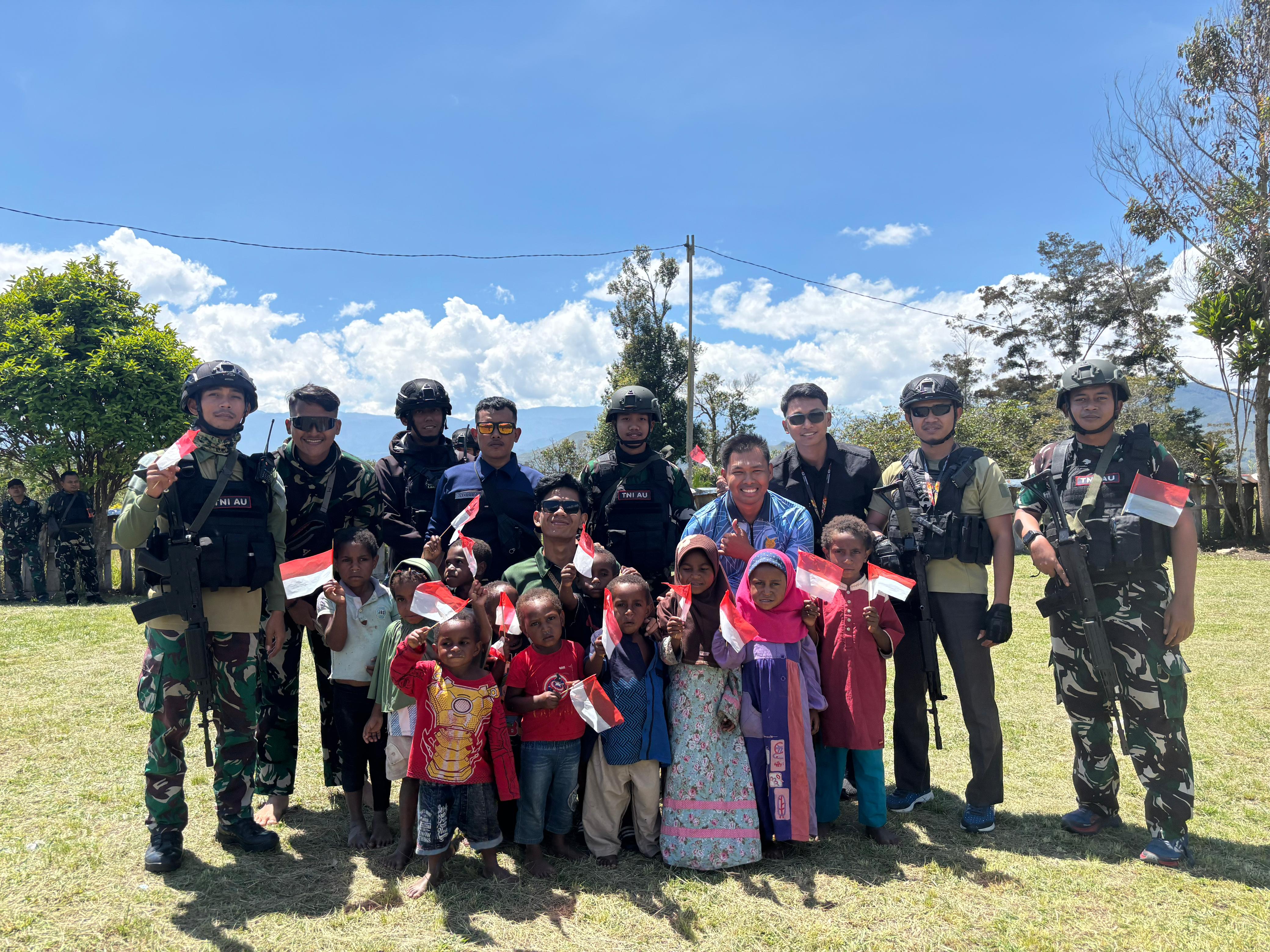 Personel TNI AU bersama anak-anak Kampung Yapema rayakan semangat kemerdekaan dengan senyum dan bendera merah putih.