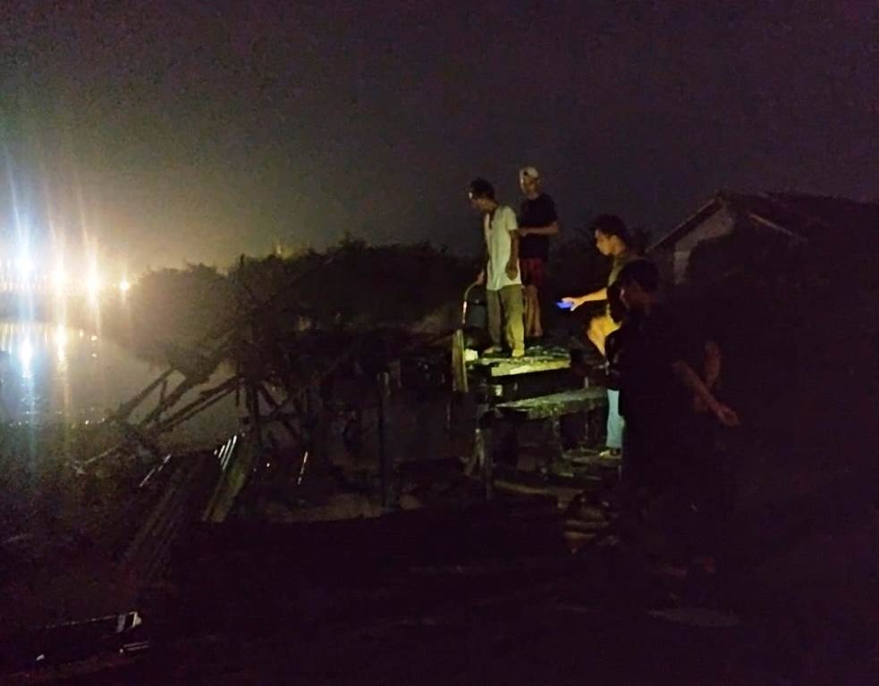 PUING: warga memeriksa puing-puing sisa kebakaran pondok keramba ikan yang terbakar.
