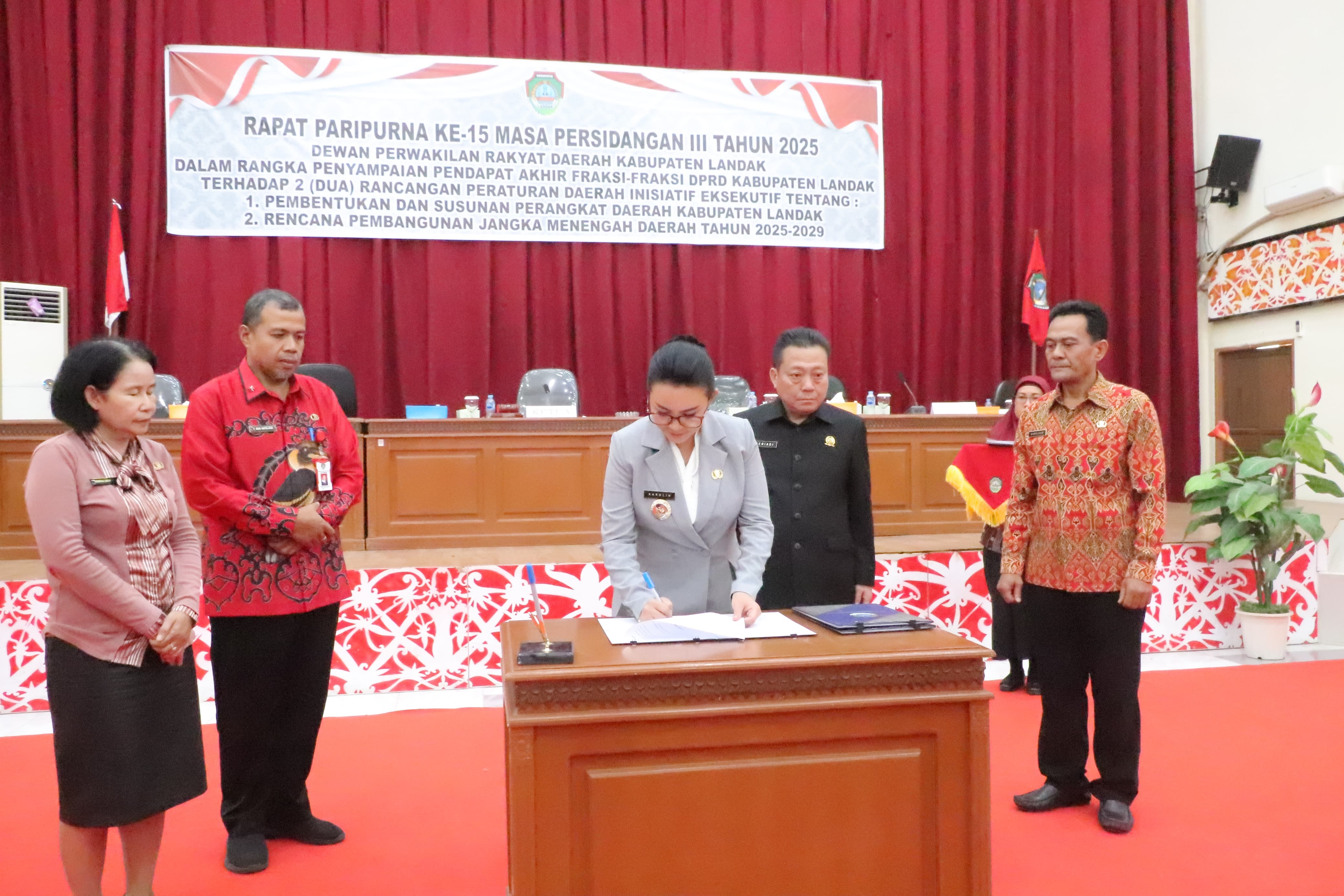 Bupati Landak Karolin Margret Natasa saat menandatangani berita acara Paripurna penyampaian pendapat akhir fraksi terhadap dua raperda strategis di Aula Kantor DPRD Landak, Kamis (7/8).