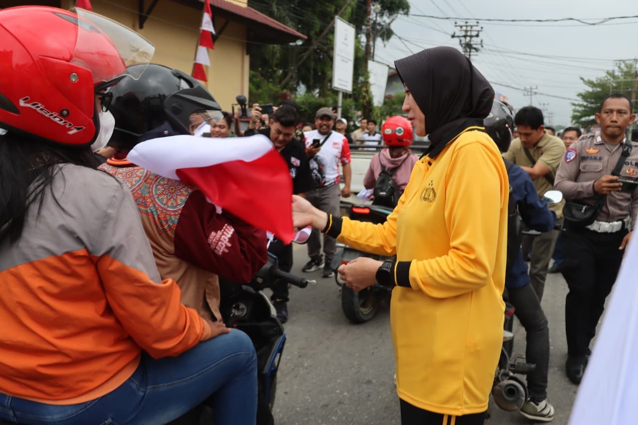 BAGIKAN: Kapolres Landak AKBP Devi Ariantari bersama Forkopimda Kabupaten Landan membagikan bendera merah putih di Tugu Pahlawan Ngabang, Jumat (8/8).