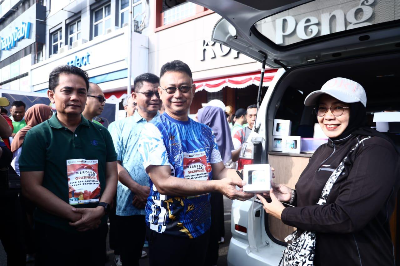 BAYAR PBB: Wali Kota Pontianak Edi Rusdi Kamtono menyerahkan souvenir kepada warga yang membayar PBB-P2 menggunakan QRIS Dinamis.