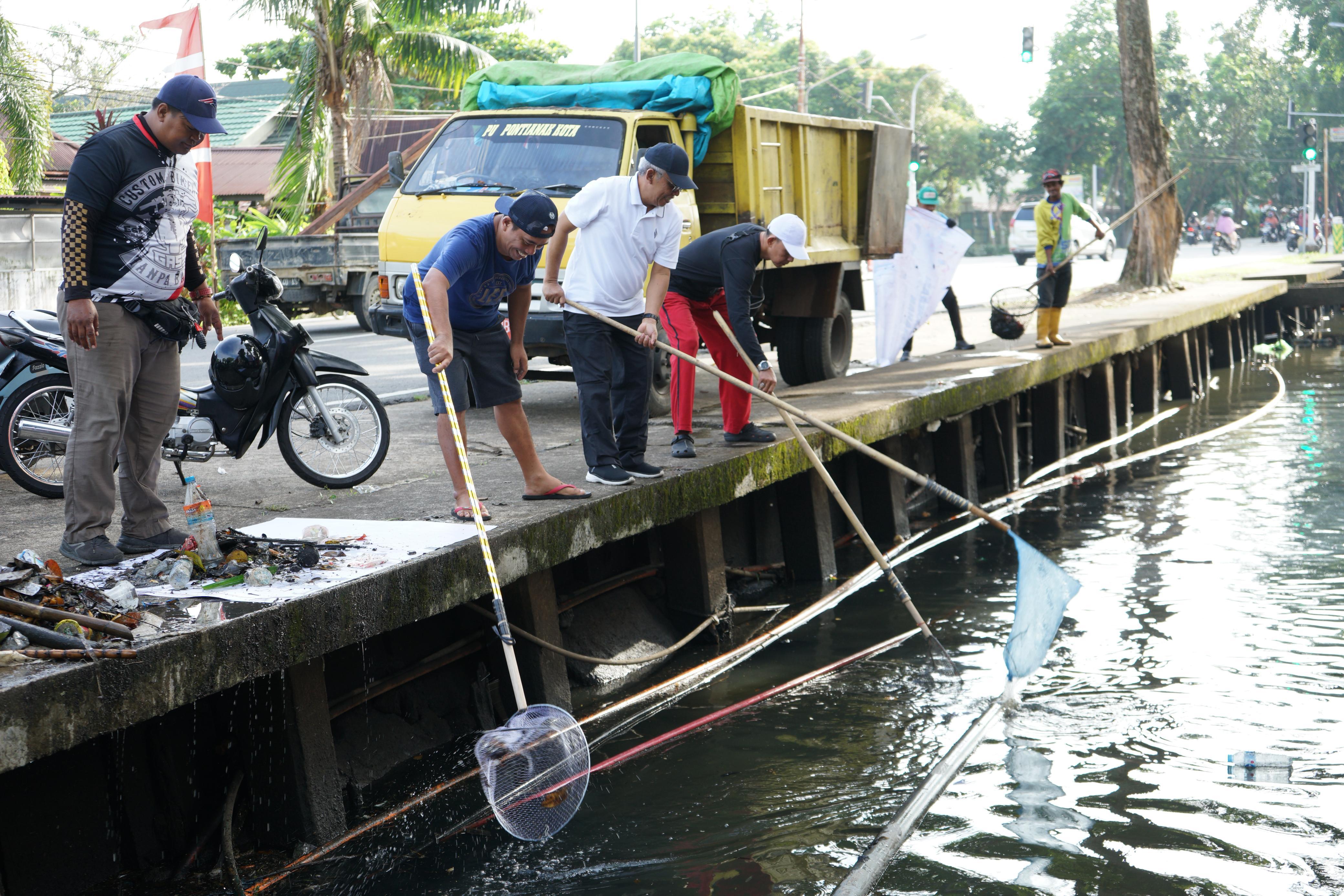 BERSIHKAN PARIT: Sekda Pontianak menjaring sampah di parit Jalan Alianyang dalam kegiatan Gotong Royong HUT ke-80 RI.