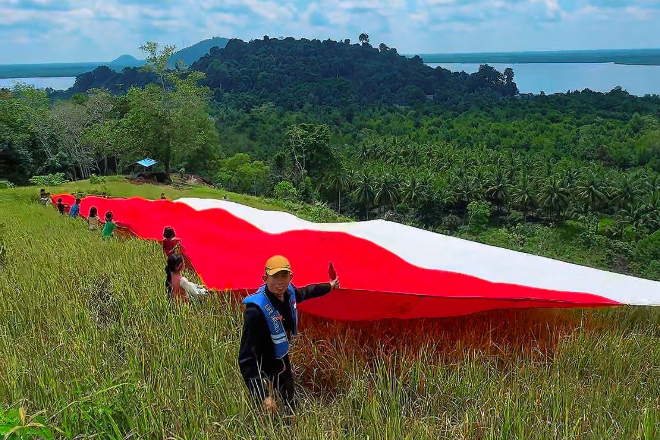 Pengibaran bendera merah putih raksasa berukuran 20 x 8 meter di Bukit Lalang Kecamatan Batu Ampar Kabupaten Kubu Raya.