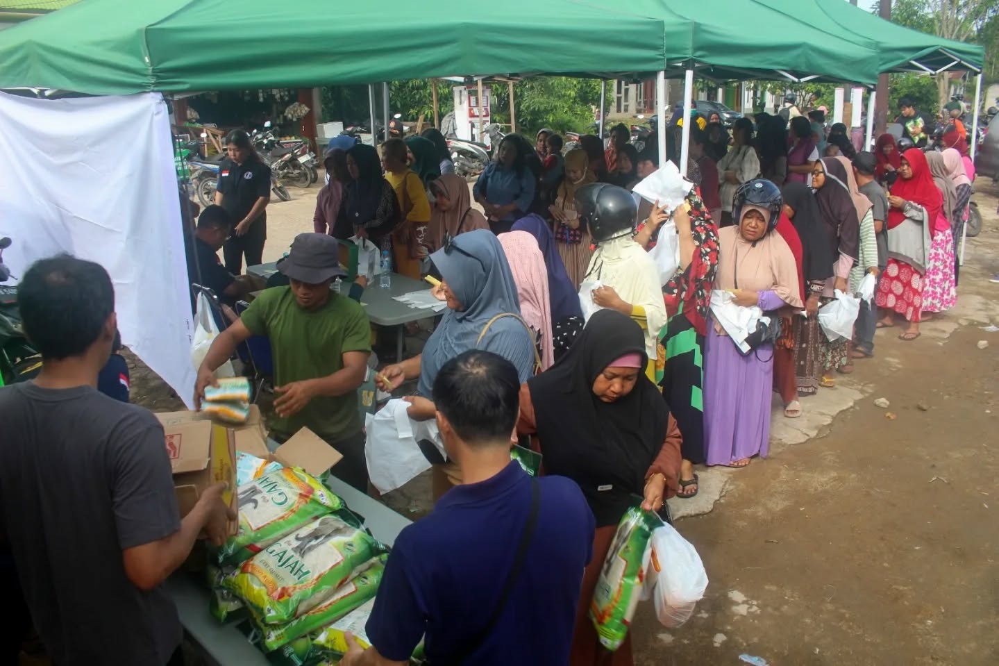 ANTRE SEMBAKO: Warga Desa Durian dan sekitarnya tampak antusias belanja paket sembako di Operasi Pasar Murah yang digelar Pemkab Kubu Raya bersama Pemprov Kalbar, Rabu (13/8) di Desa Durian,