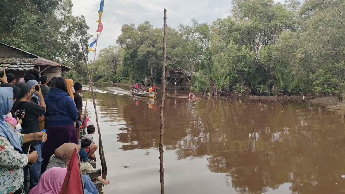 LOMBA SAMPAN: Warga Sungai Pinyuh menyaksikan lomba sampan tradisional yang dilaksanakan di jalan Pancasila.