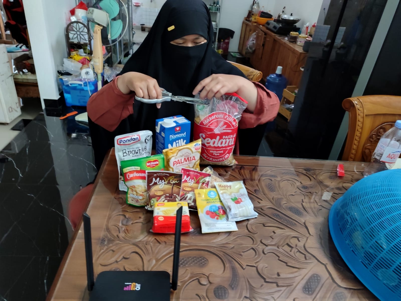 Annisya, Owner Aisyah Kitchen saat melakukan proses produksi kue untuk pesanan online di rumahnya di Jl Husein Hamzah Pontianak. Annisya mengandalkan HiFi Air Indosat untuk mendukung usaha rumahannya.