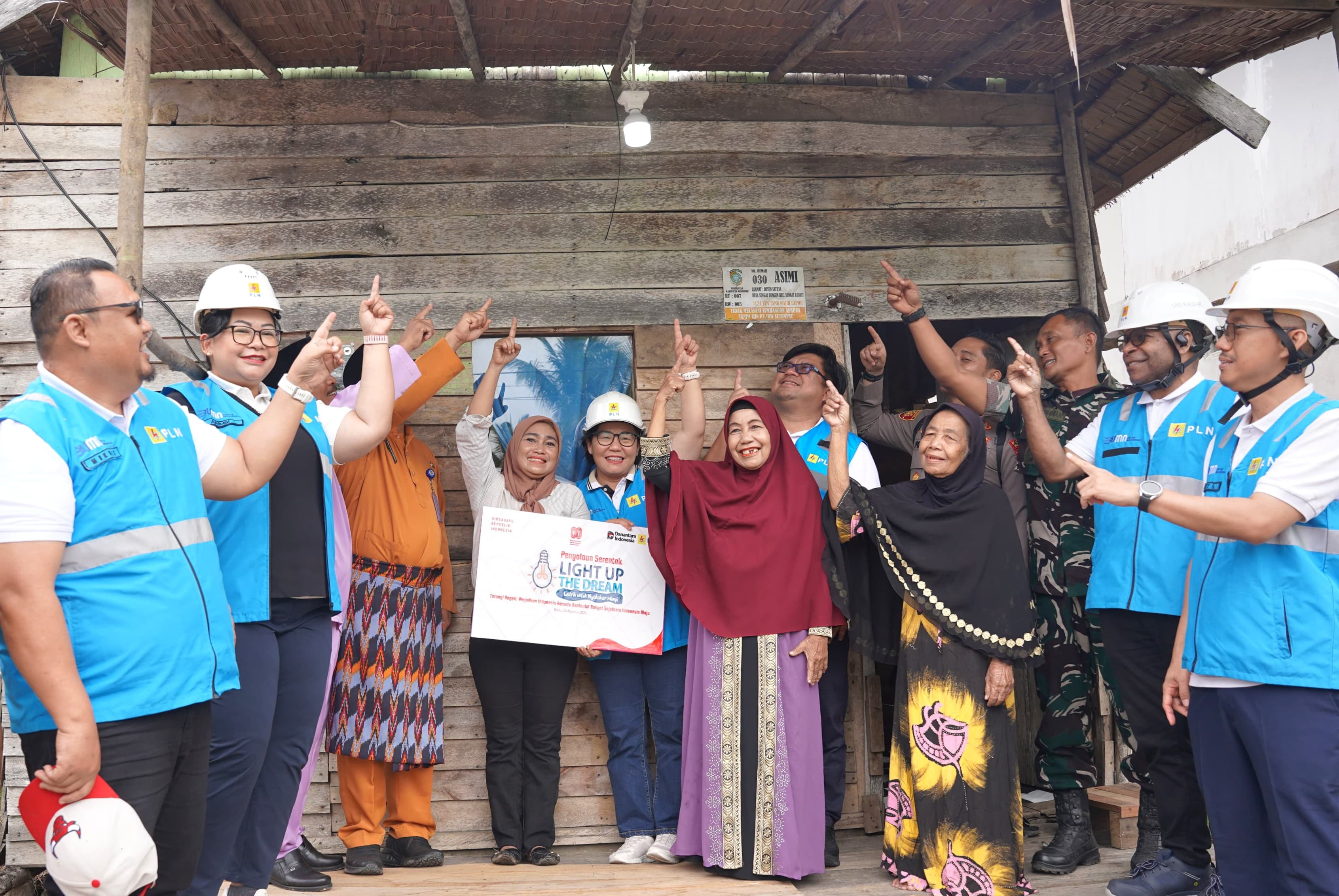 General Manager PLN UID Kalimantan Barat, Maria G.I. Gunawan, berfoto bersama keluarga Ibu Wiwik dan Manajemen PLN setelah penyalaan listrik di rumah mereka melalui program Light Up The Dream (LUTD).