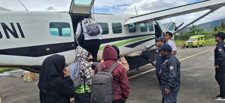 Warga menaiki pesawat di Bandara Moenamani, Dogiyai. Satgas Korpasgat turut menjaga keamanan dan kelancaran aktivitas.