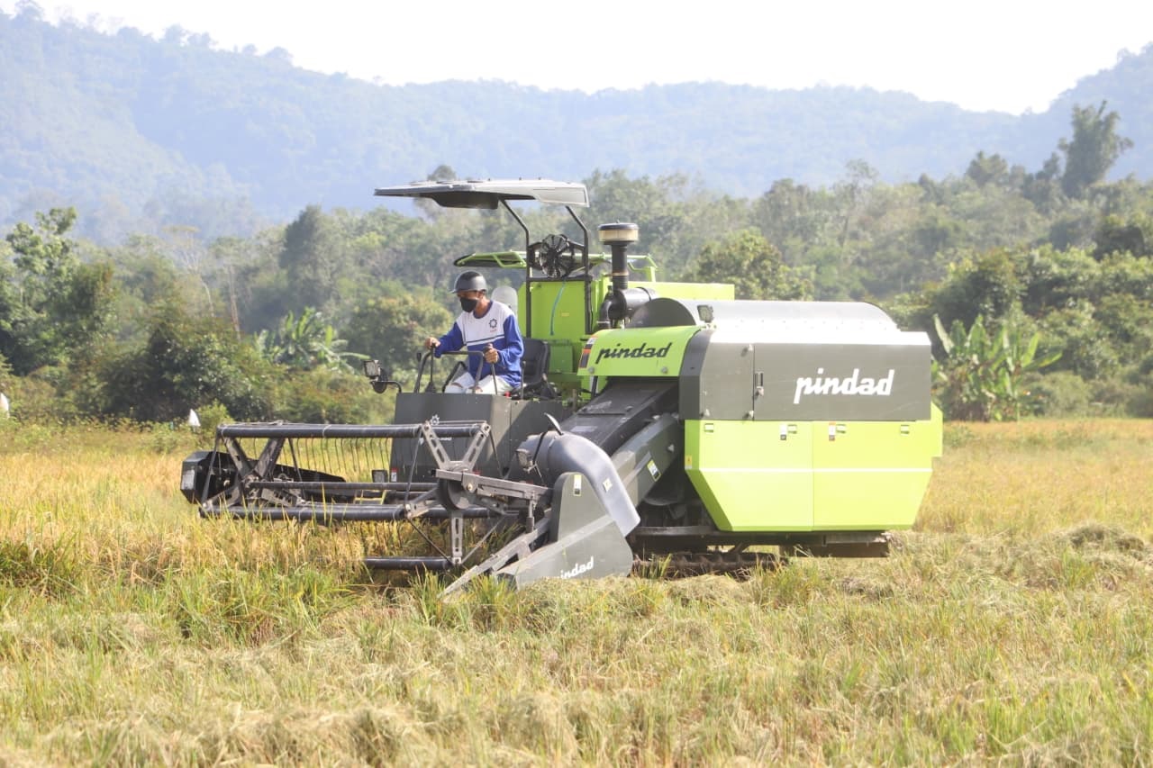 TEKNOLOGI : Seorang petani saat menggunakan teknologi pertanian modern berupa mesin panen padi combine harvester.