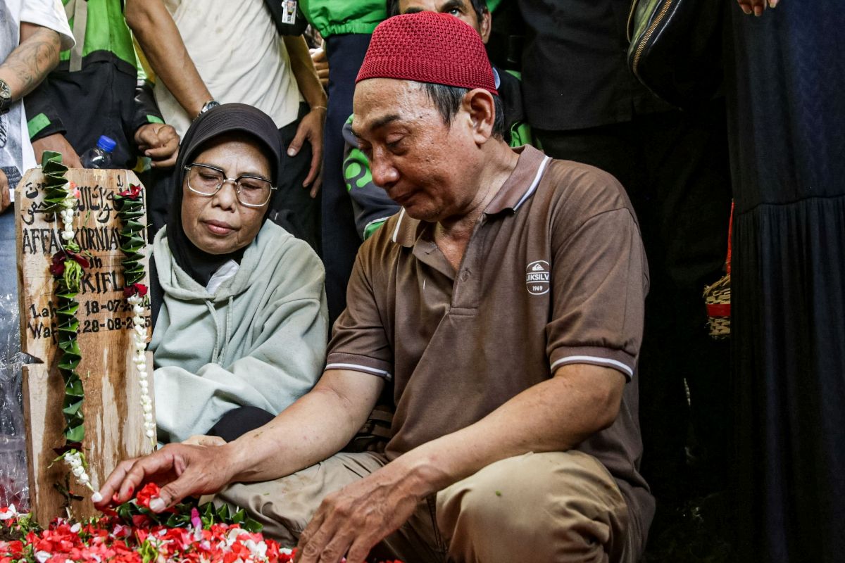 Keluarga pengemudi ojek online Affan Kurniawan menaburkan bunga di TPU Karet Bivak di Jakarta, Jumat (29/8/2025).