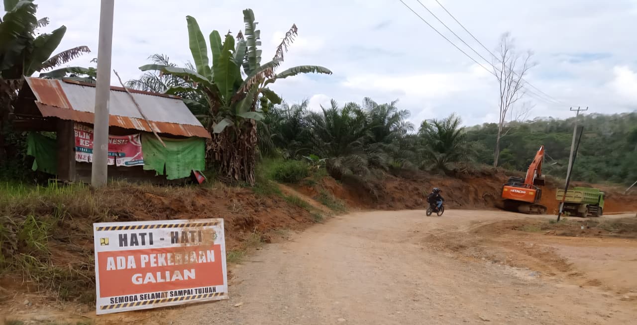 Proyek pembangunan jalan di daerah hulu Kalbar, dengan tanda peringatan untuk keselamatan pengguna jalan.