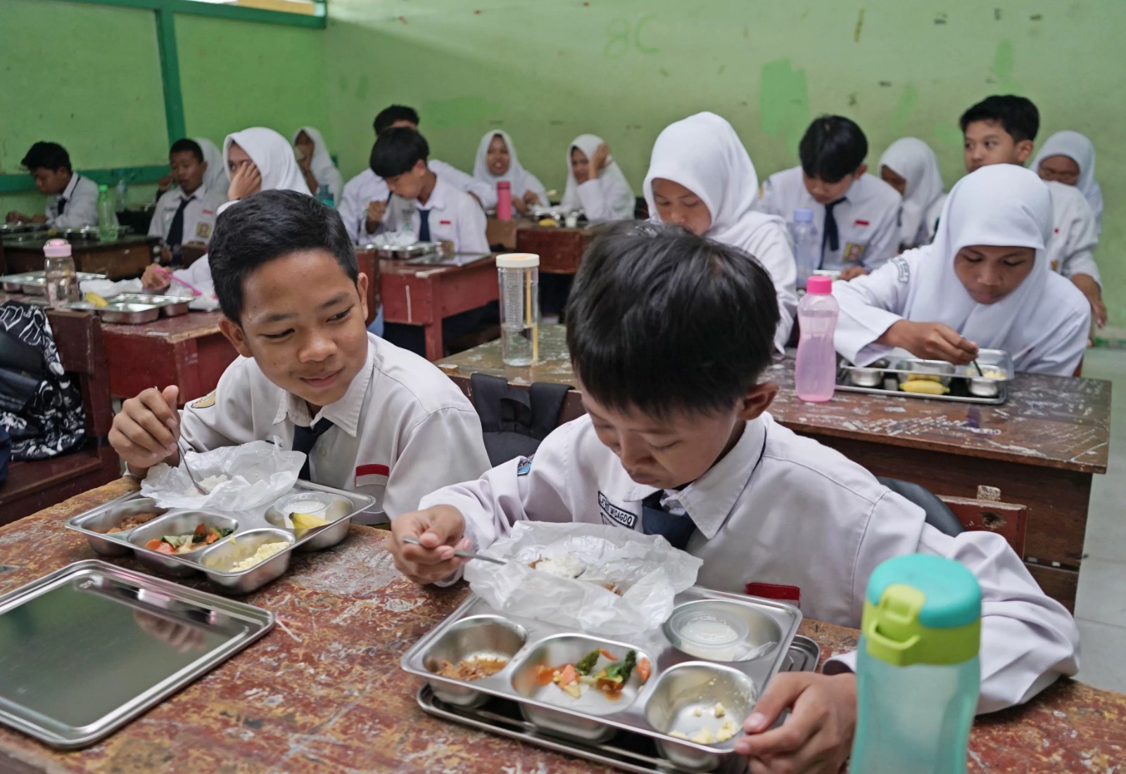 Pelajar SMP Negeri 9 Pontianak Jalan Pangeran Natakusuma menyantap menu makan bergizi gratis. Hari pertama pelaksanaan makan bergizi