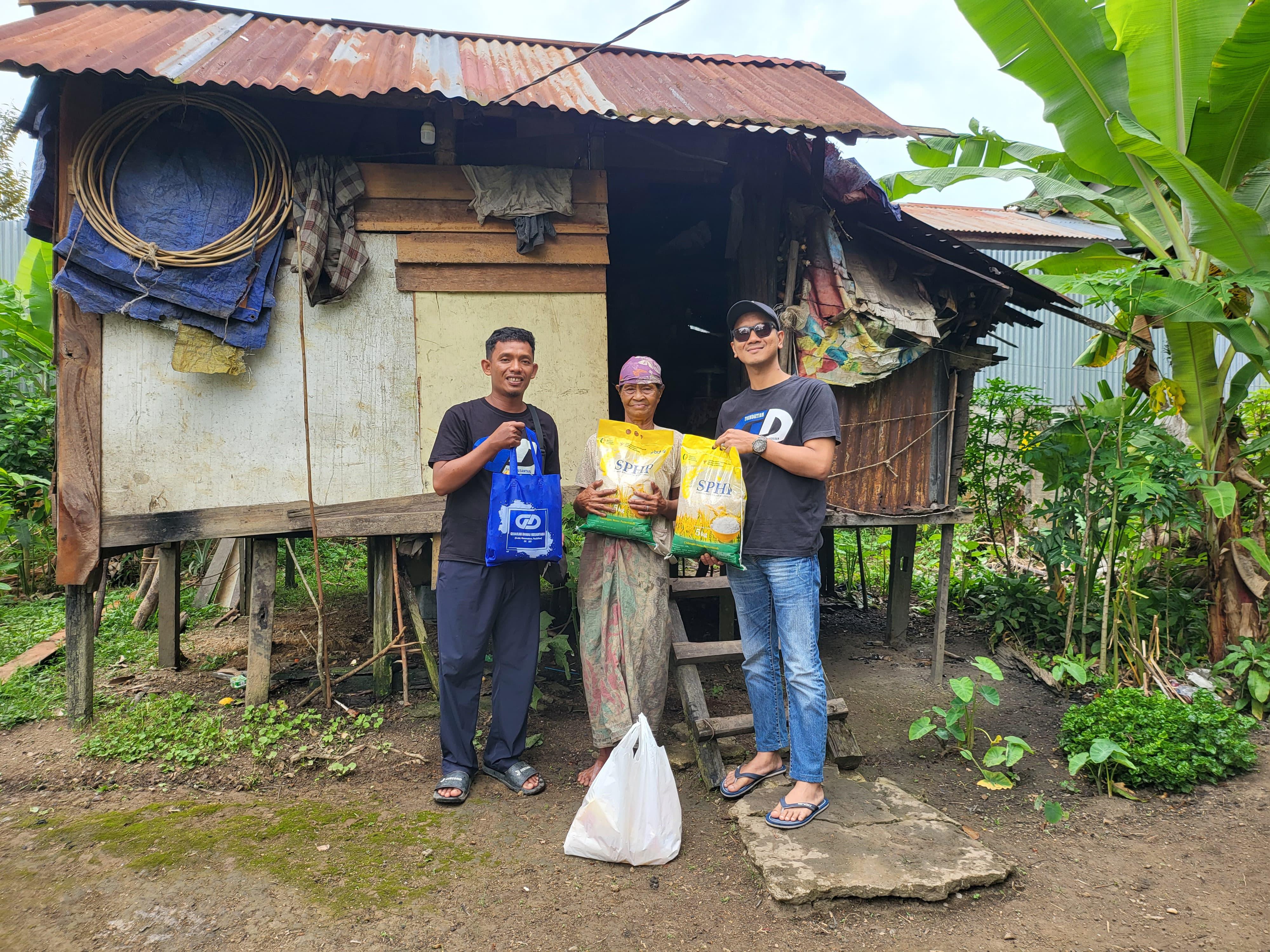 Founder Gerakan Damai Nusantara, Merianto (kiri) bersama rekannya menyalurkan bantuan sembako kepada salah satu warga kurang mampu Nenek Radiah (tengah) di Desa Kelakik, Kecamatan Nanga Pinoh