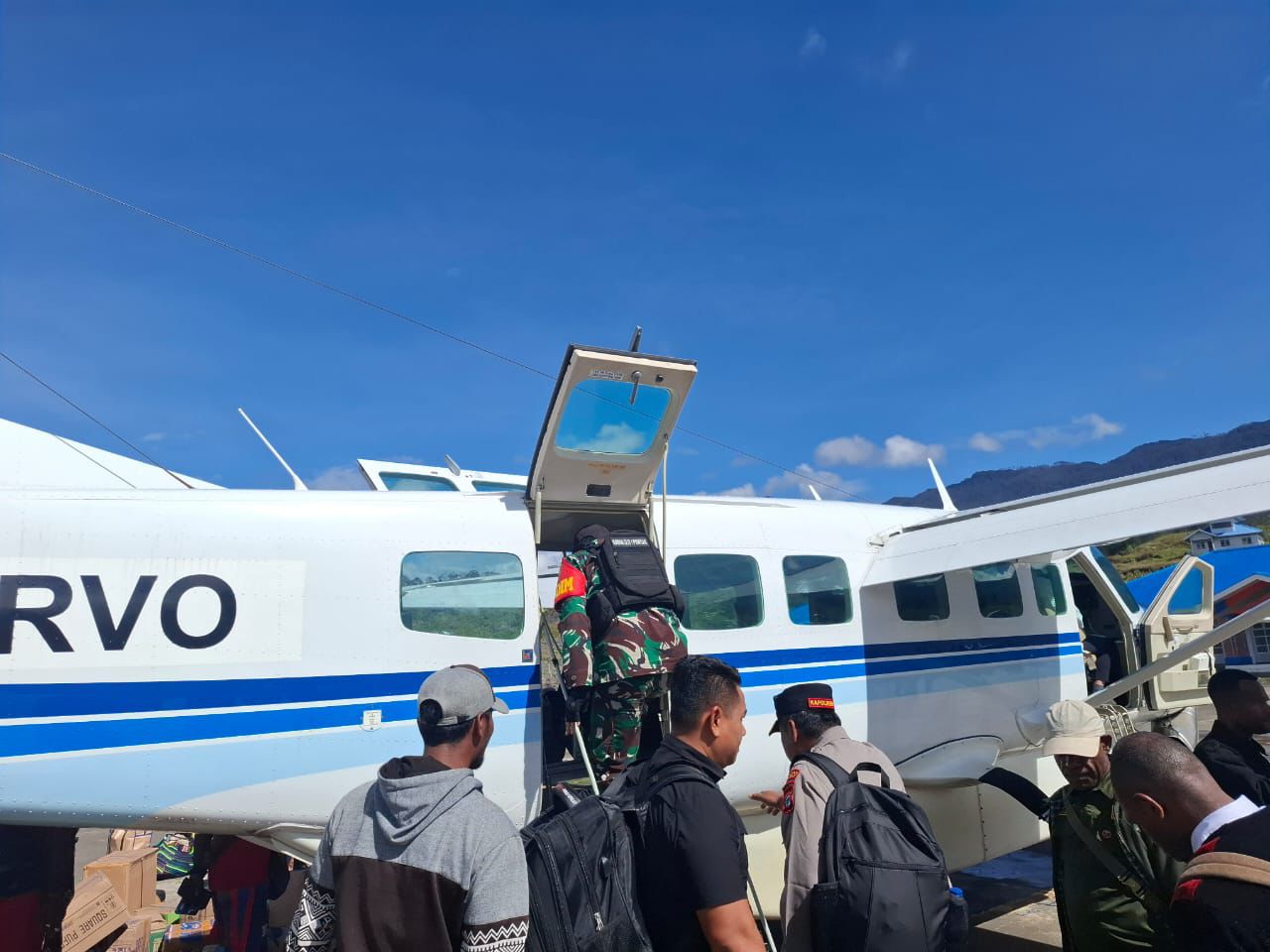 Personel TNI dan Polri mendampingi keberangkatan Sekda Puncak menuju Distrik Sinak untuk menghadiri acara adat bakar batu.