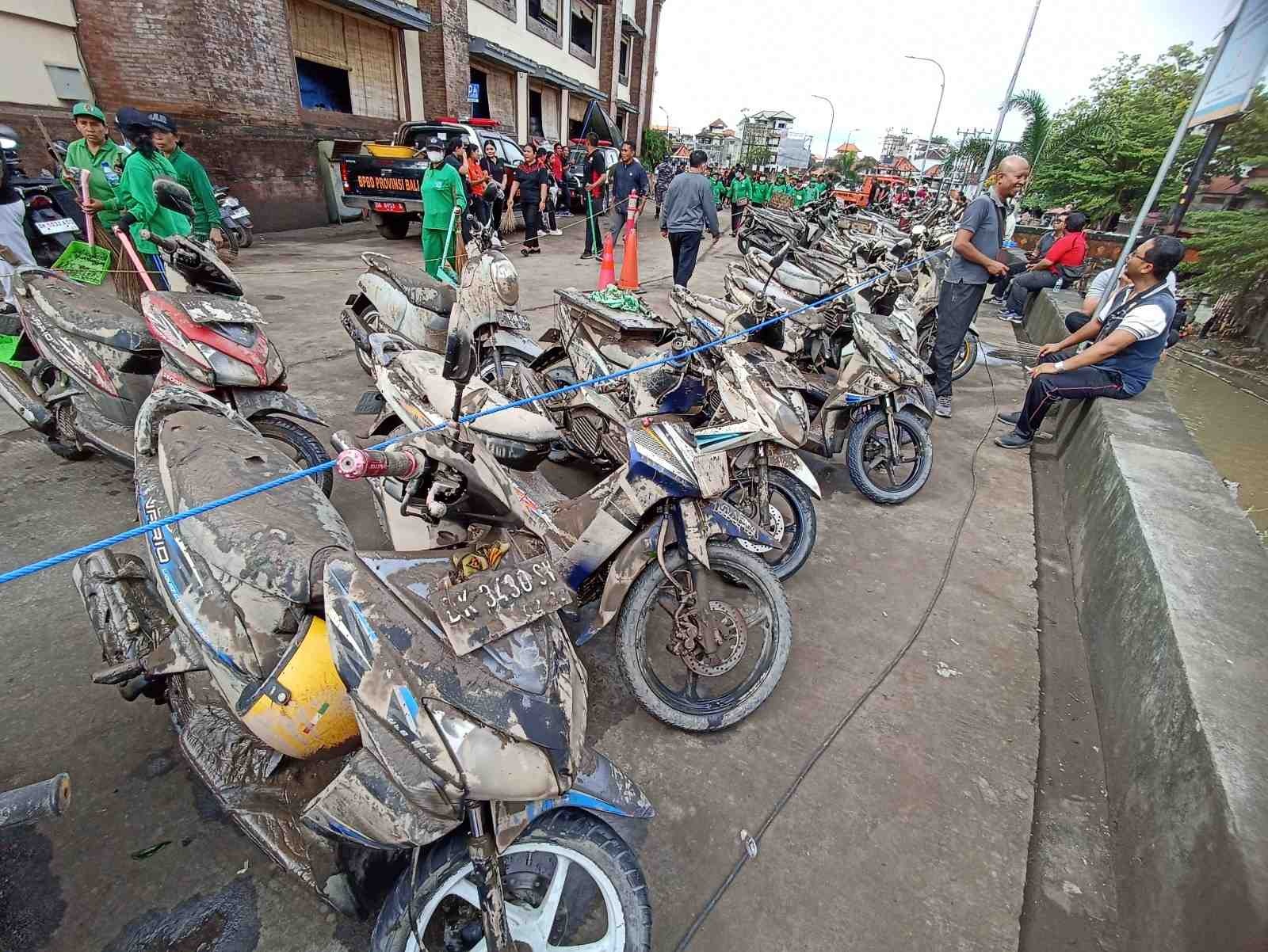 DAMPAK BANJIR: Sejumlah kendaraan dan bangunan rusak akibat banjir yang melanda Pulau Bali, Rabu (12/9) kemarin. Sejumlah warga dibantu petugas polri dan TNI membersihkan lokasi yang terdampak banjir.