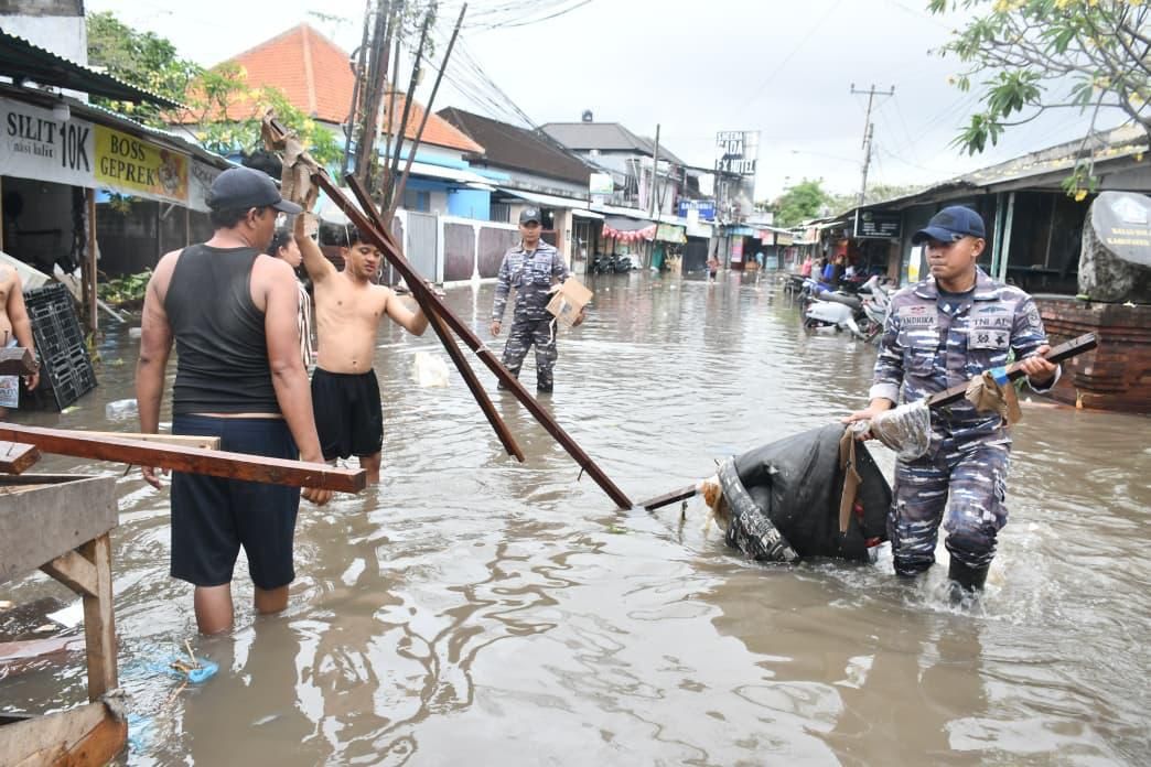 Prajurit TNI AL membantu korban tedampak banjir di Bali membersihkan beberapa lokasi dan mengevakuasi korban menggunakan ambulans.