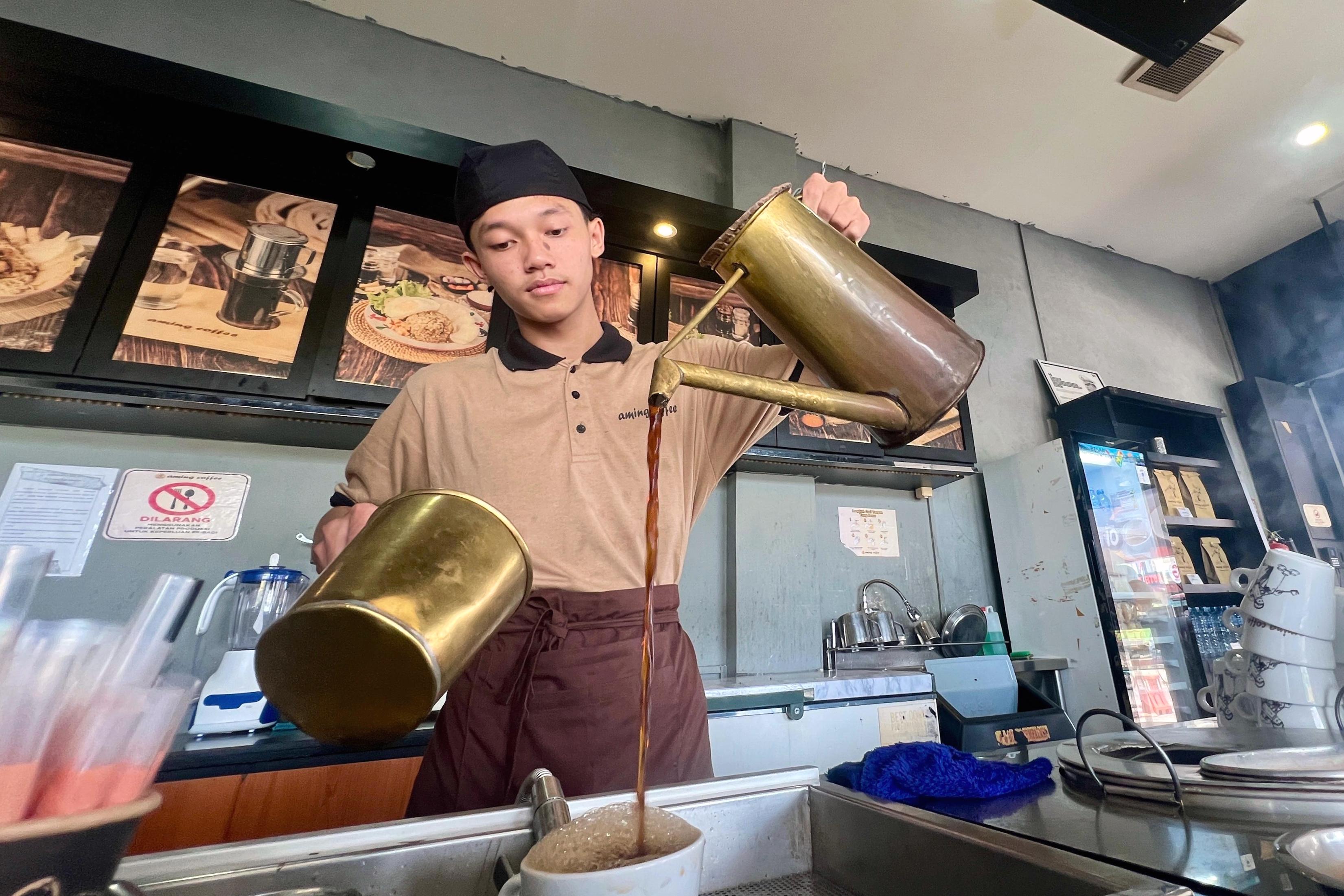 Salah satu barista Aming Coffee Nanga Pinoh, Kabupaten Melawi sedang membuat kopi pesanan pengunjung. Banyaknya gerai Aming Coffee di Kalbar membuka lapangan pekerjaan bagi penduduk lokal.