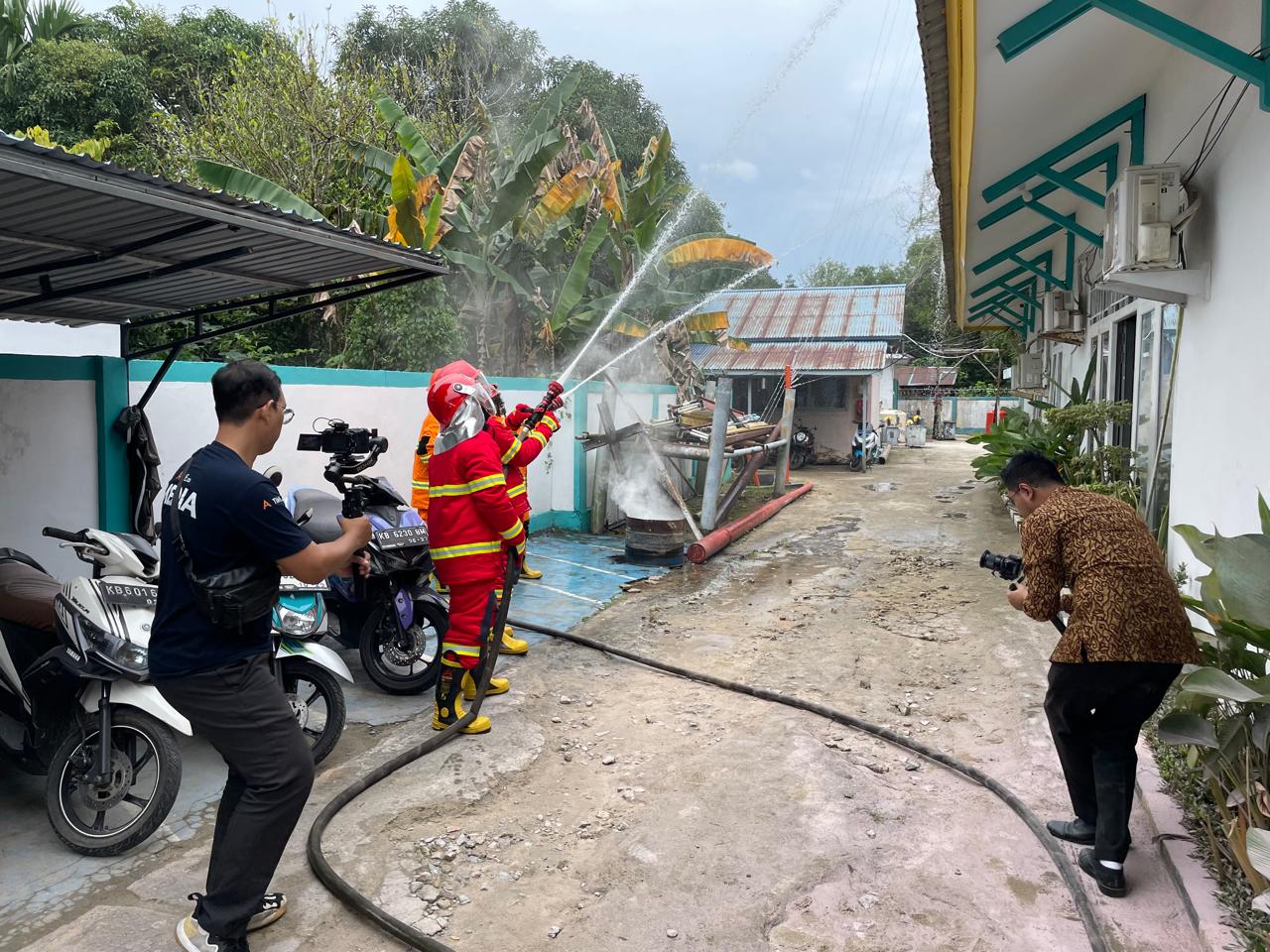 Para petugas sigap mempraktikkan simulasi pemadaman kebakaran dalam rangkaian Sosialisasi K3 & KAM serta Simulasi Tanggap Darurat yang digelar PLN UP3 Ketapang.