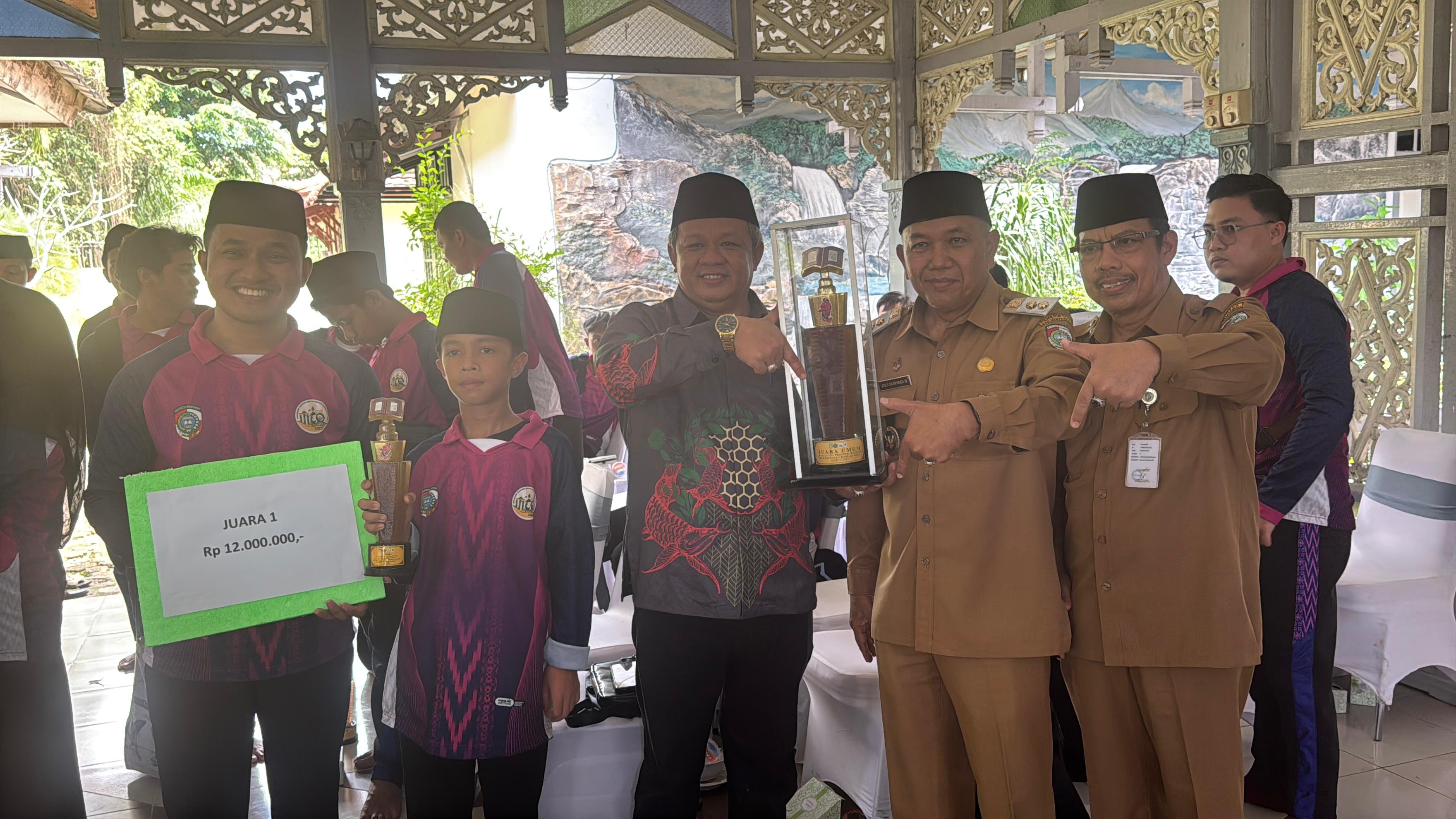 PIALA: Ketua DPRD Kabupaten Mempawah, Safruddin Asra (tengah) turut menunjukan piala juara umum MTQ XXXIII.