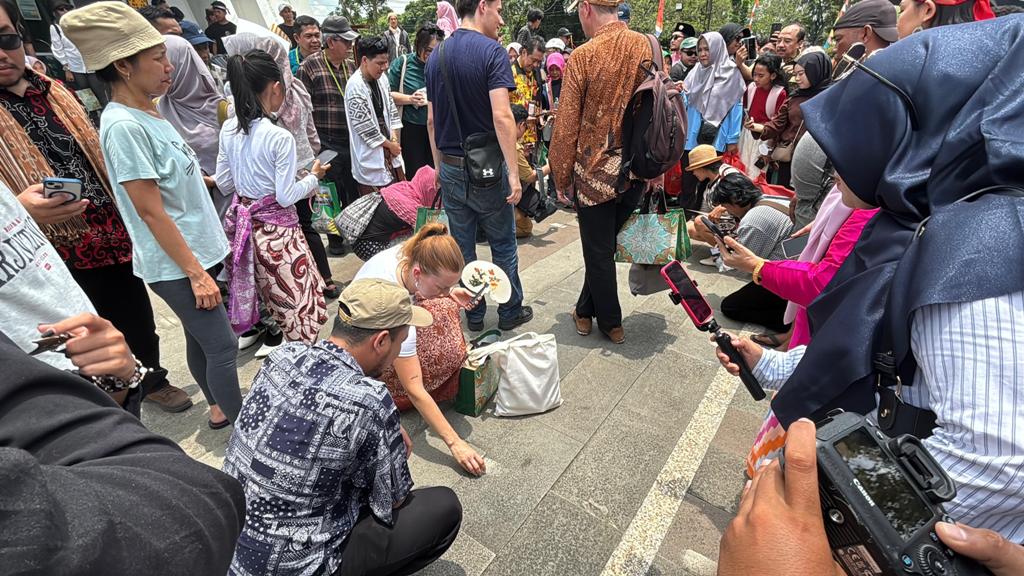 KULMINASI: Para wisatawan asal Jerman tengah mencoba mendirikan telur di kawasan Tugu Khatulistiwa saat Kulminasi Matahari.