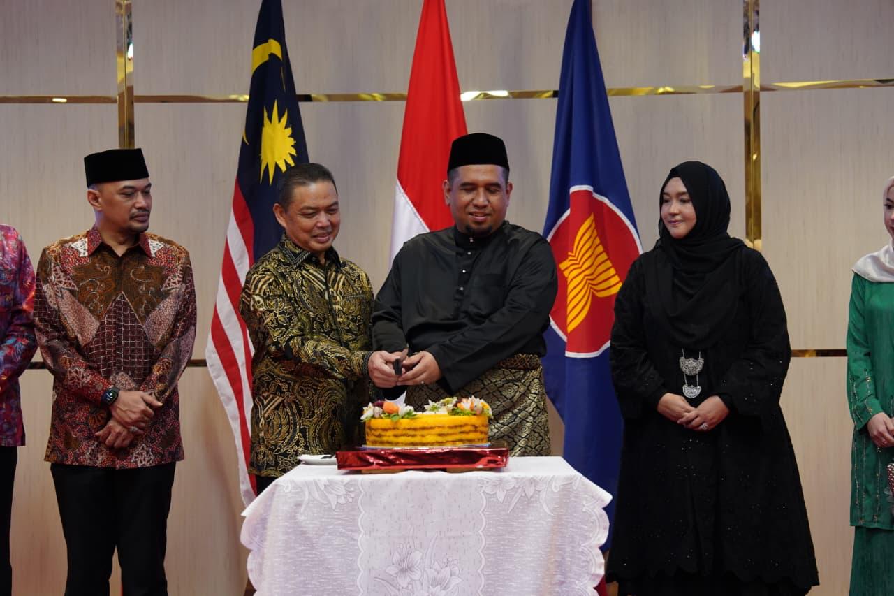 POTONG : Gubernur Kalbar, Ria Norsan, bersama Konsul Malaysia di Pontianak, Azizul Zekri, memotong ketan kuning sebagai tanda perayaan Majlis Resepsi Hari Kebangsaan Malaysia ke-68 dan Hari Malaysia