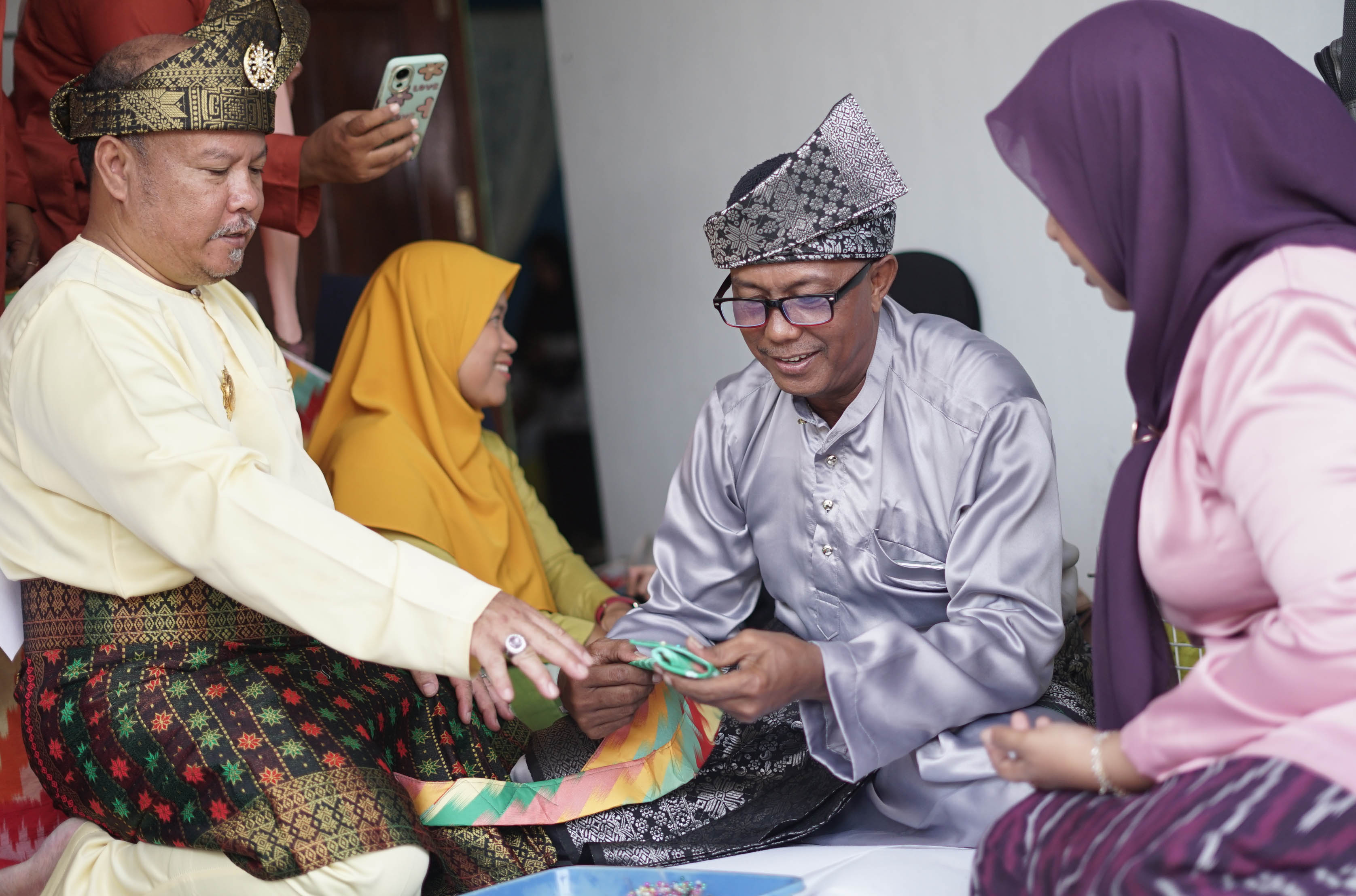 MELIPAT TANJAK: Suherman (baju kuning muda) menularkan kemampuannya ke sejumlah masyarakat yang mengikuti pelatihan  Seni Melipat Tanjak di Kampung Tanjak Jalan Selat Panjang,Gang Amal,Kelurahan Siant