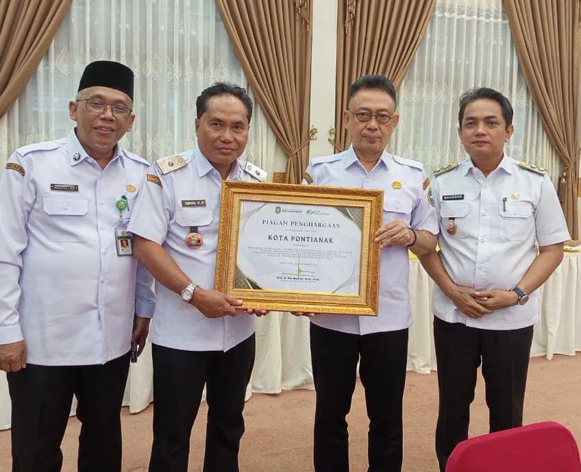 PIAGAM: Kepala Dinas Tenaga Kerja Kota Pontianak, Ismail menyerahkan piagam Paritrana Award BPJS Ketenagakerjaan yang diterimanya kepada Wali Kota Pontianak Edi Rusdi Kamtono.