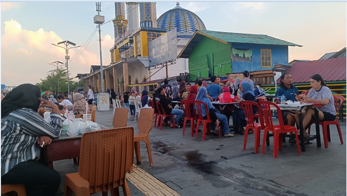 SENJA: Warga menikmati senja di pinggir sungai waterfront Gang Kamboja.