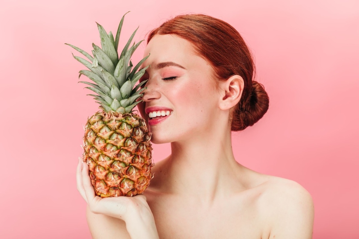 Ilustrasi wanita sedang memegang buah nanas.