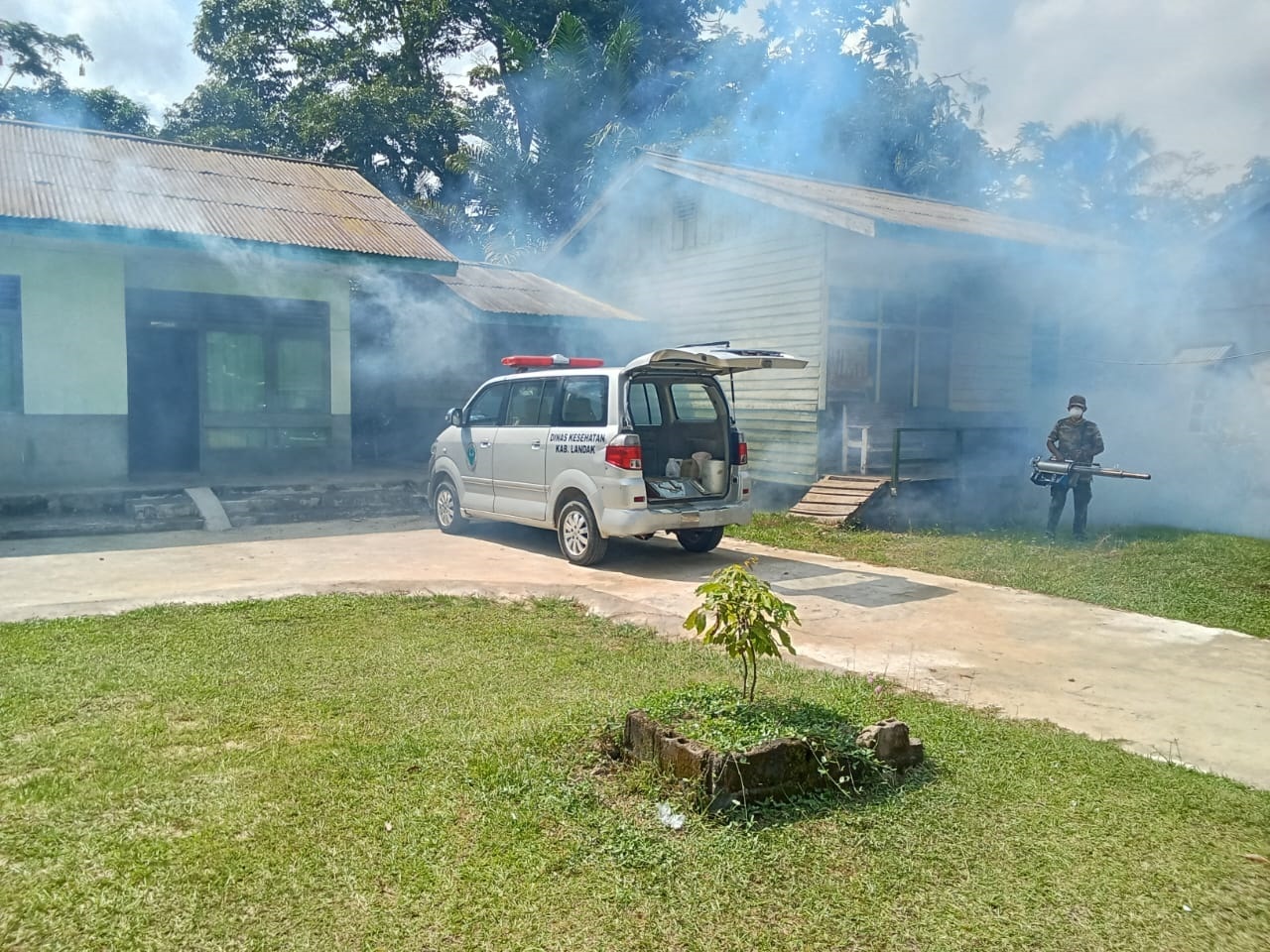 FOGGING : Anggota Koramil 01/Menjalin bersama tim gabungan Puskesmas dan pemeritah kecamatan saat melakukan fogging di sekitar rumah warga di Desa Menjalin untuk mencegah DBD