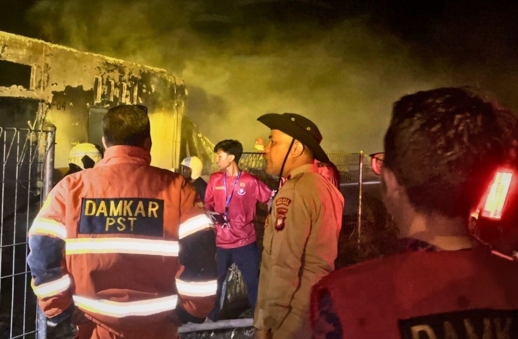 PADAMKAN API: Petugas pemadam kebakaran bersama warga berupaya memadamkan api yang melalap deretan mess karyawan PT MUBK di Desa Kuala Mandor A, Senin (6/10) malam.