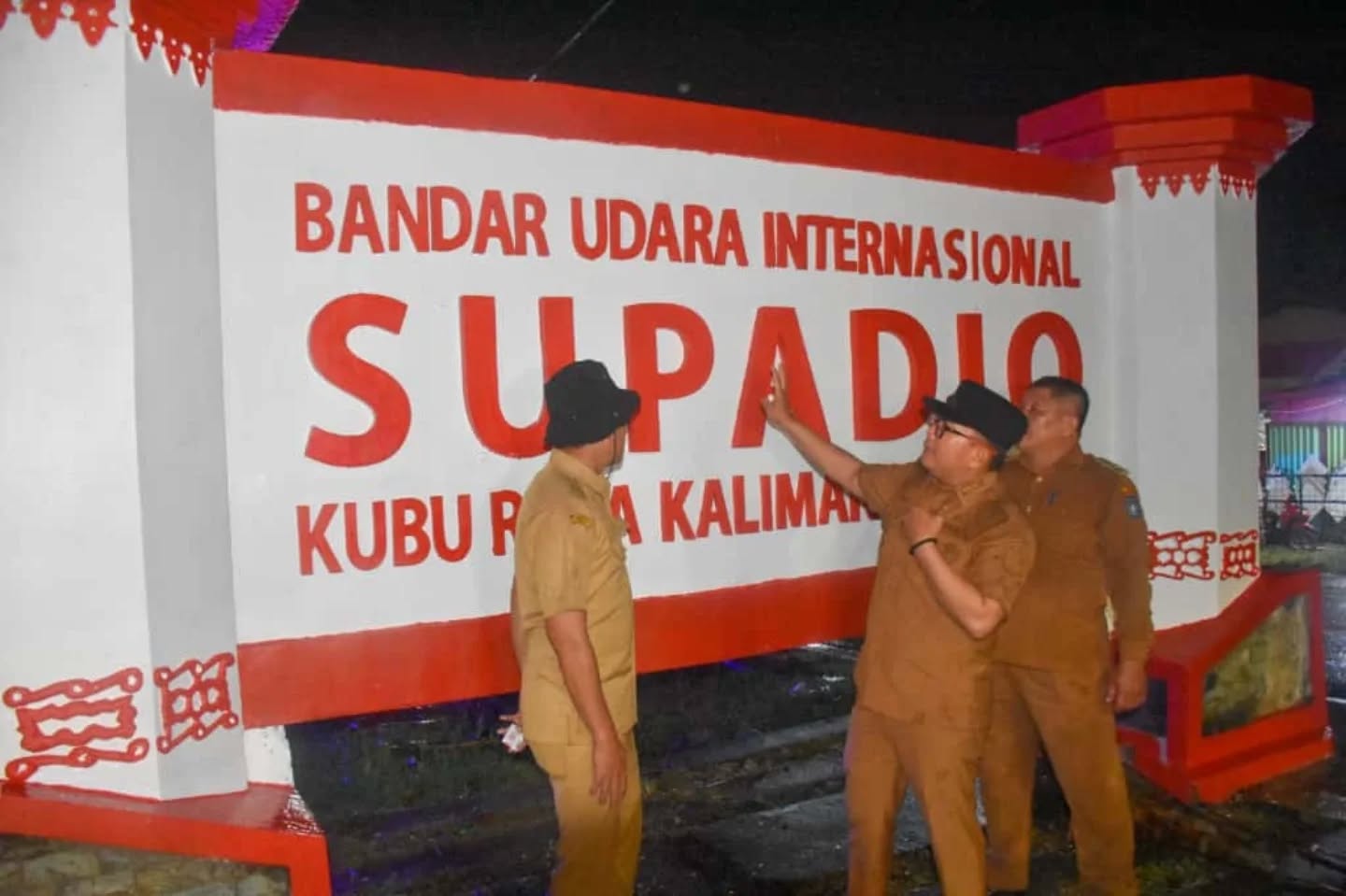 TUNJUK: Bupati Kubu Raya, Sujiwo menunjuk papan nama Bandara Internasional Supadio di Jalan Ahmad Yani 2, Sungai Raya, Kabupaten Kubu Raya, Rabu (8/10).