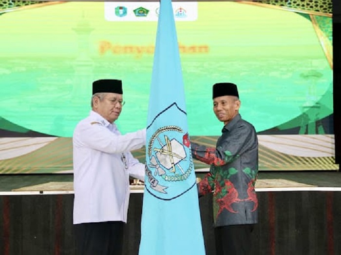 Sekda Kalbar Harisson menyerahkan bendera LPTQ kepada Ketua Kafilah Kalbar, H. Andi Musa, saat pelepasan peserta STQH Nasional ke-28 di Pontianak.