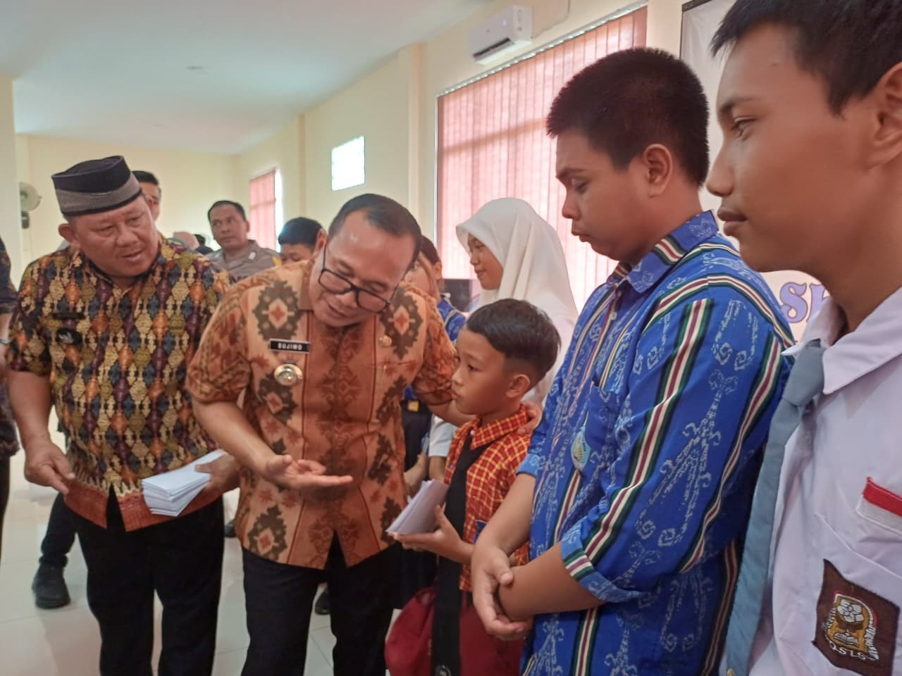 SERAHKAN BEASISWA: Bupati Kubu Raya Sujiwo menyerahkan beasiswa pendidikan kepada pelajar berprestasi penerima bantuan Dana Desa Limbung, Kamis (9/10).