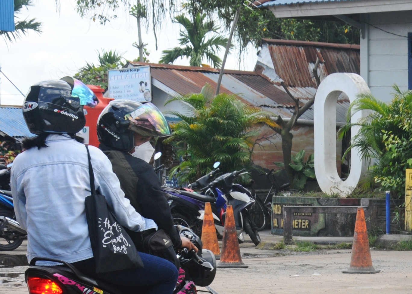 TITIK NOL: Warga melintas di titik nol kilometer yang berada tak jauh dari penyeberangan feri di Siantan