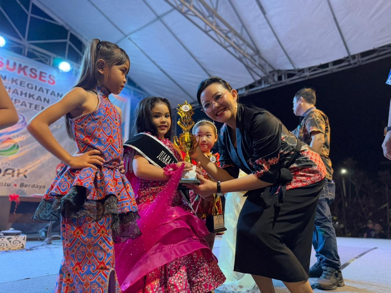 SERAHKAN TROFI: Bupati Landak Karolin Margret Natasa menyerahkan piala kepada pemenang lomba pada malam penutupan HUT ke-26 Pemerintah Daerah Kabupaten Landak di Kampung Budaya GOR Patih Gumantar, Nga