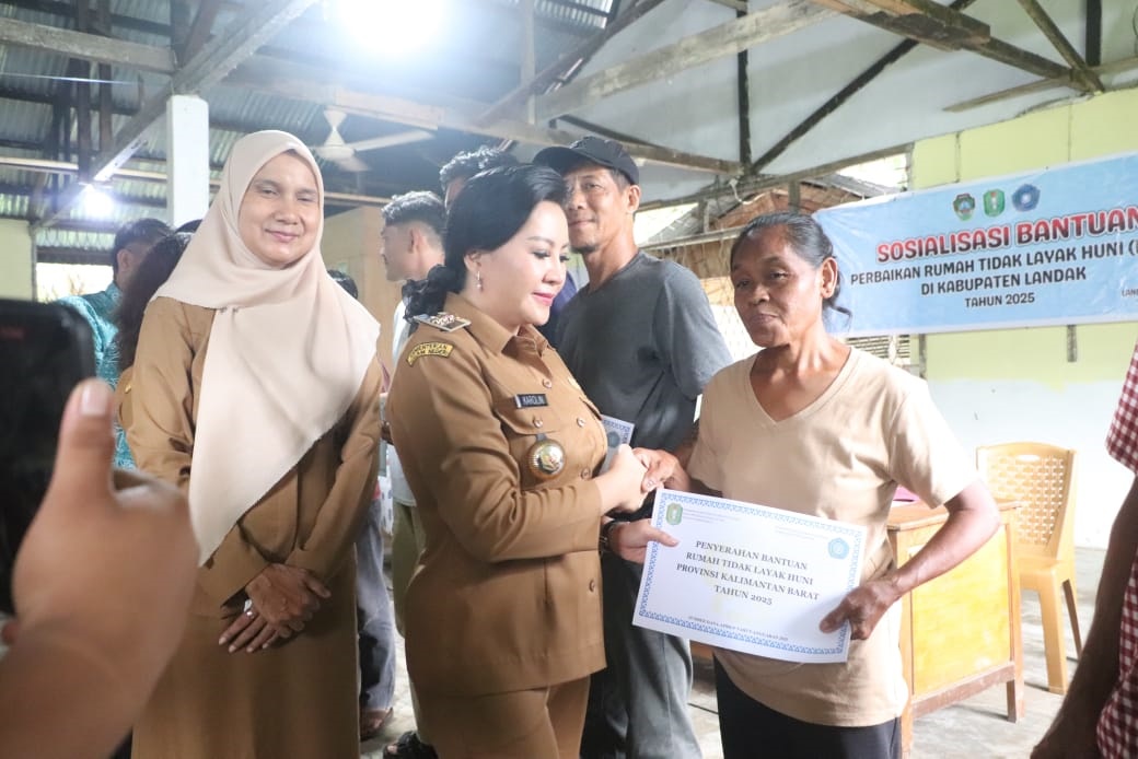 BANTUAN : Bupati Landak Karolin Margret Natasa saat menyerahkan bantuan perbaikan rumah tidak latak huni di Desa Amboyo Selatan, Kecamatan Ngabang.