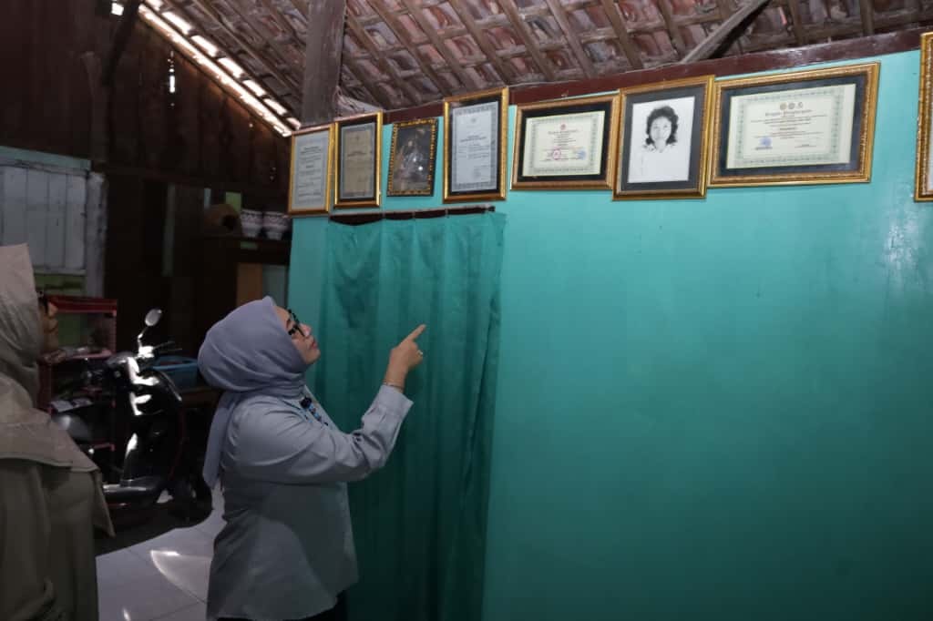 KENANG SOSOK PEMBERANI: Menteri PPA Arifah Fauzi memandang foto Marsinah di kediaman almarhumah di Desa Nglundo, Nganjuk, kemarin.