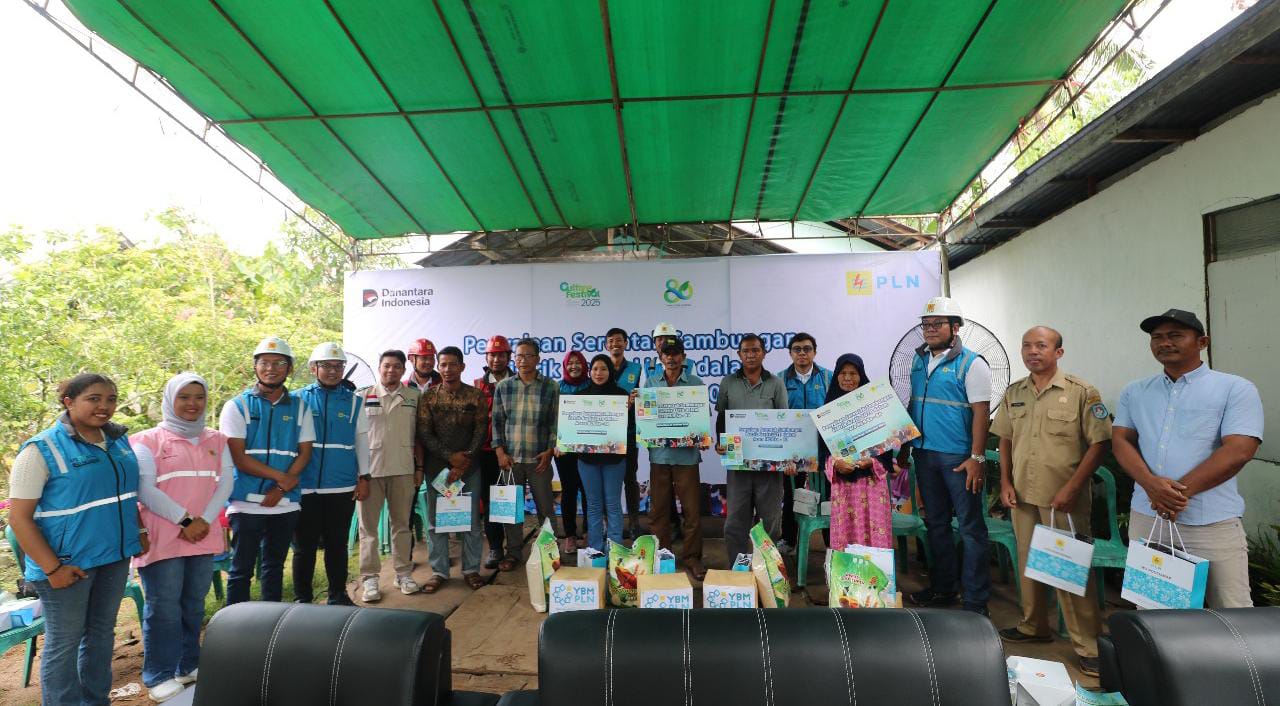 Manager PLN UP3 Pontianak, Blasius Gani, berfoto bersama penerima manfaat LUTD, warga desa Rasau Jaya Tiga, senyum bahagia terpancar diwajah mereka setelah penyalaan serentak program LUTD.