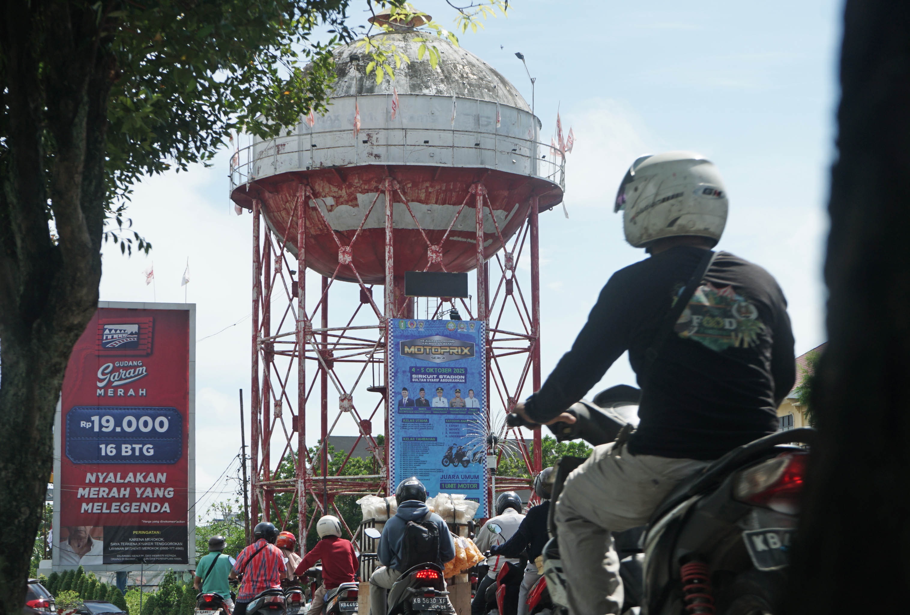 MENARA AIR: Warga menunggu di lampu merah Jalan Ahmad Yani yang ada menara airnya.