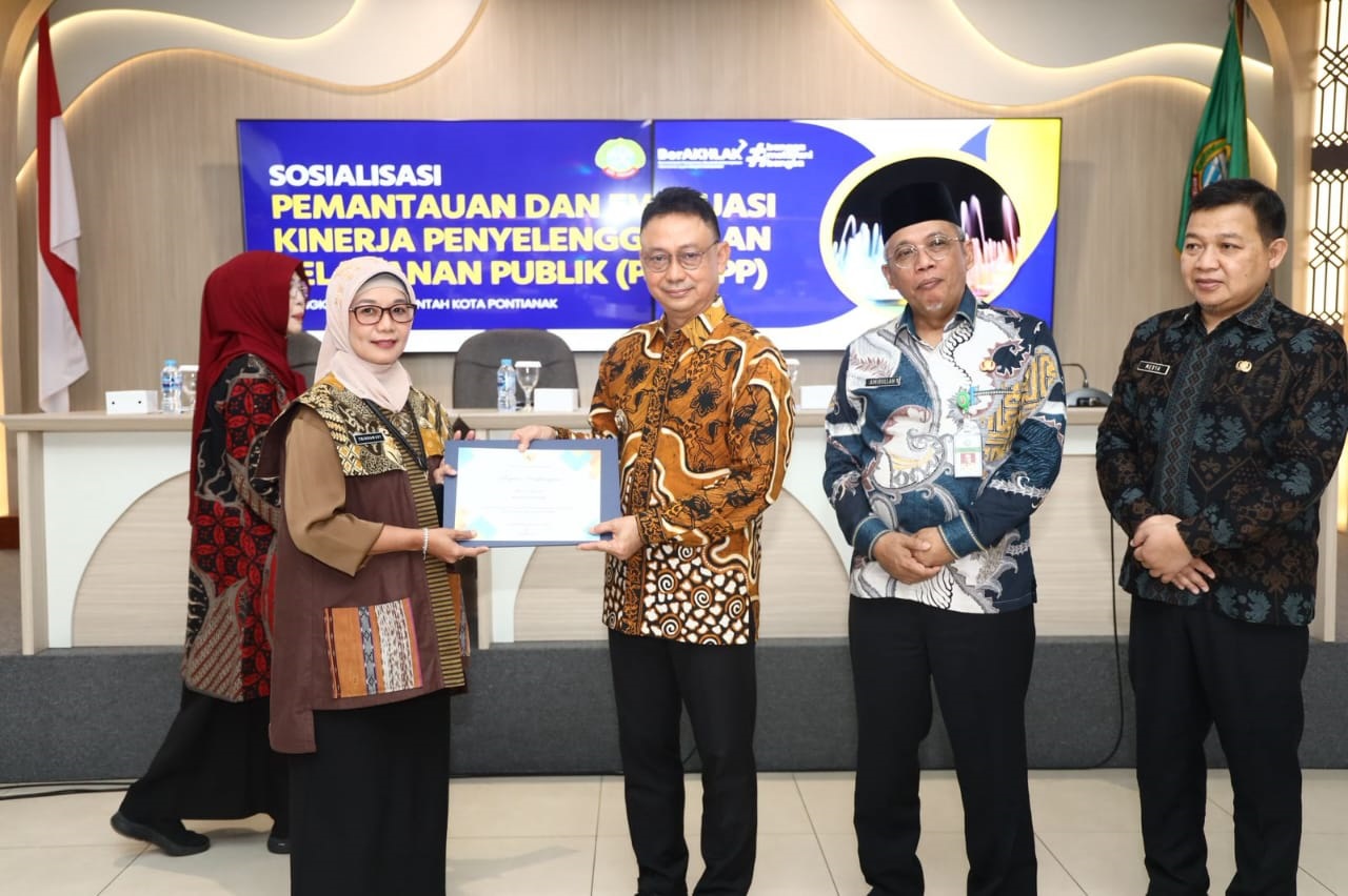 Kepala Dinas Sosial Kota Pontianak, Trisnawati saat menerima penghargaan dari Wali Kota Pontianak, Edi Rusdi Kamtono.
