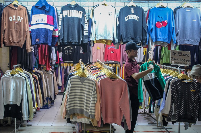 Pedagang menata pakaian bekas yang dijual di Pasar Senen, Jakarta, Jumat (24/10/2025). Menteri Keuangan Purbaya Yudhi Sadewa mengatakan pihaknya akan melarang praktik impor bal pakaian bekas ilegal dalam karung atau balpres karena dapat merugikan negara d