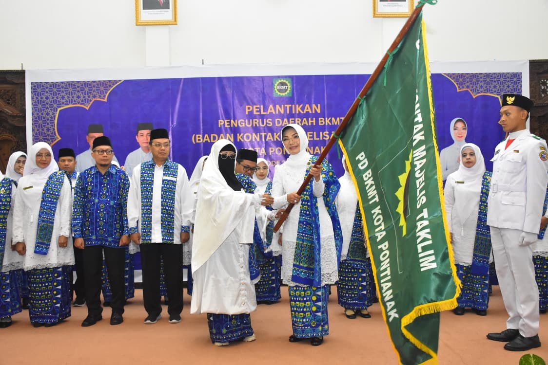 Serah terima bendera pataka dari PW BKMT Provinsi Kalbar, Ustazah Sangadah kepada Ketua PD BKMT Kota Pontianak 2025-2030, Yanieta Arbiastutie.