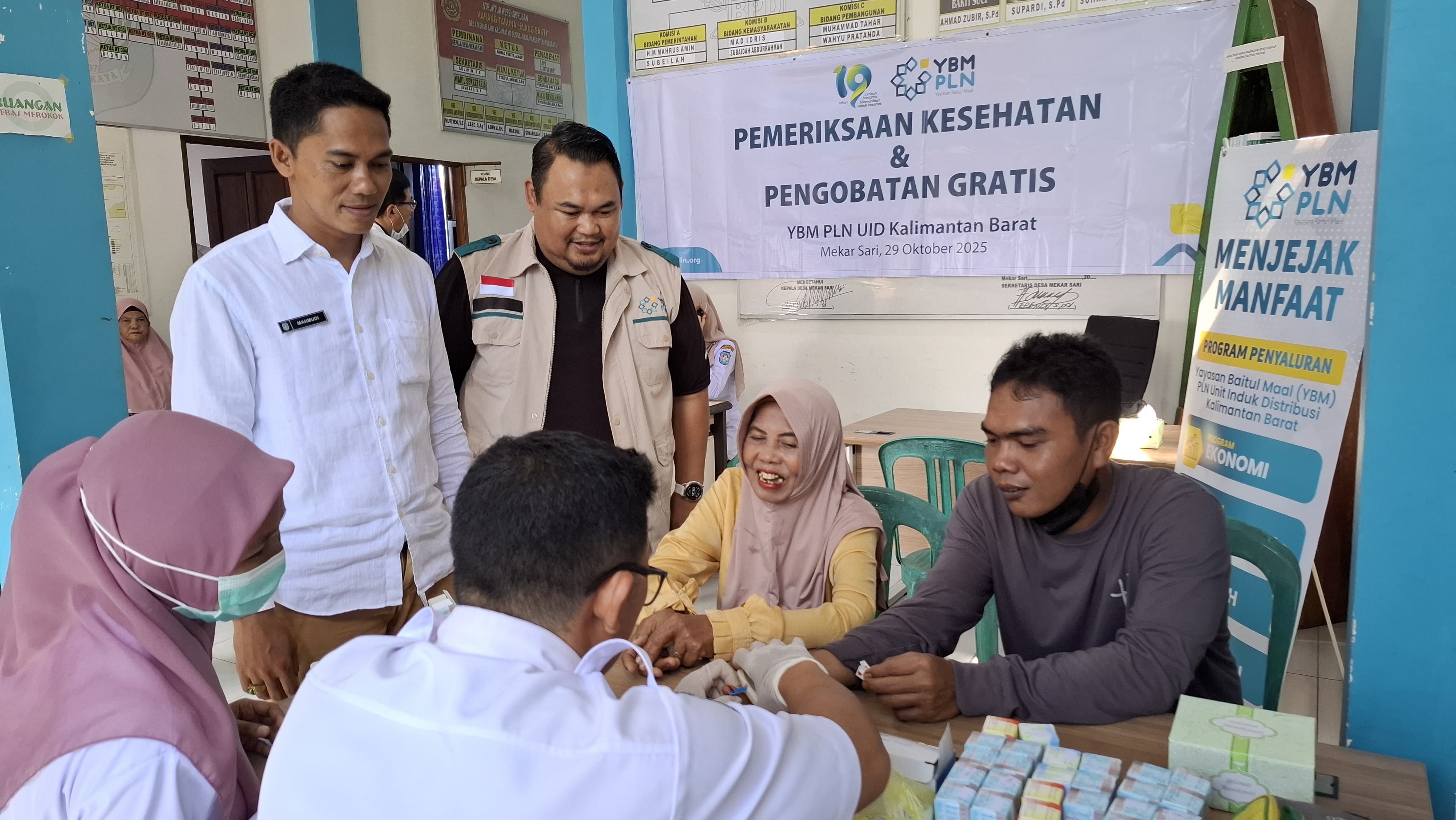 Ketua YBM PLN UID Kalimantan Barat, Mukhlis Zarkasih (baju hitam) bersama tim medis, dan masyarakat tengah melaksanakan program pemeriksaan kesehatan gratis & pengobatan gratis di desa MekarSari,Rasau