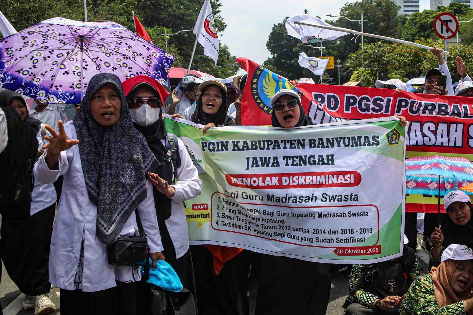 DEMONSTRASI: Sejumlah guru dari berbagai daerah menggelar aksi di kawasan Patung Kuda, Jakarta, Kamis (30/10). Dalam aksinya, mereka antara lain menuntut pengangkatan P3K/ASN bagi guru madrasah swasta