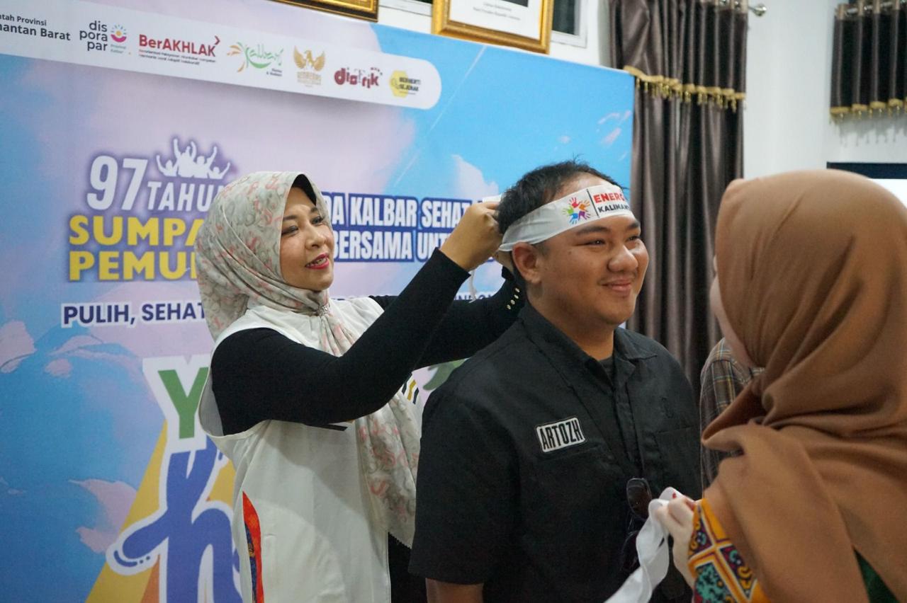 PEMUDA : Kepala Disporapar Kalbar, Windy Prihastari memasangkan ikat kepala kepada salah satu peserta dalam kegiatan Youth Healing Space sebagai simbol dukungan terhadap semangat generasi muda menuju